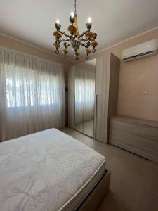 Un dormitorio con una cama y una lámpara de araña en Casa aperanza, en Nápoles