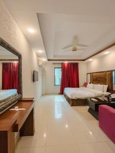 Una habitación de hotel con dos camas y un espejo. en Shanze Hotel And Suites, en Lahore