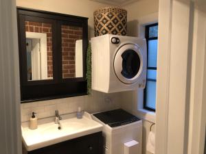 Un baño con lavabo y lavadora. en The Bungalow - Luxurious & Calm - Beach and Bush Retreat, en Valla Beach 18 fotos más