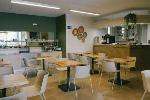a restaurant with wooden tables and white chairs at Kumba in Nea Chora in Chania