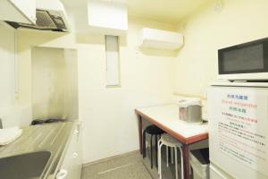 a kitchen with a counter and a table with a microwave at 花乃郷 池袋f in Tokyo +7 photos