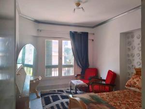a bedroom with two red chairs and a window at Gadou Rooms -Private & Shared Stays in Port Said Best Location in Port Said