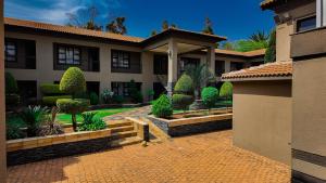 a house with a courtyard with trees and bushes at Ondjo Yetu in Benoni