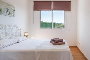 ein weißes Bett in einem Zimmer mit Fenster in der Unterkunft Azzure in Lloret de Mar + 17 Fotos