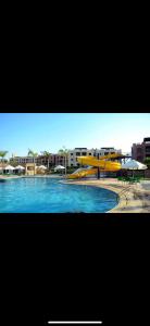 ein Swimmingpool mit einem gelben Sonnenschirm und etwas Wasser in der Unterkunft Chalet in Dawwār Abū Duray‘ah ‘Abd al Karīm