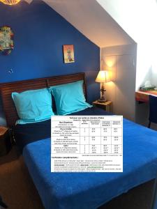 a bedroom with a blue bed with a calendar on it at Villa Eugénie Melun in Melun