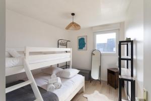 Un dormitorio con dos literas y un espejo. en Ti Cosy - 7min de la Plage, en Fréhel