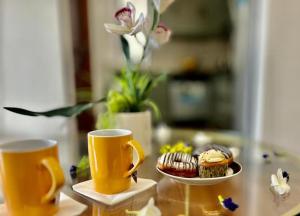 two cups and a plate of cupcakes on a table at AEONSKY RESIDENCE Luxury One Bedroom Apartment in Negombo