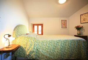 Colle di Buggianoにあるla casa nel borgoのベッドとランプ付きのテーブルがある寝室