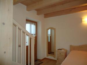 a bedroom with a bed and a mirror at Appartamenti Camere Agritur Masi Brenta in Rovereto