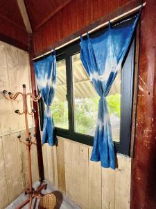 ein Fenster in einem Raum mit einem blauen Vorhang in der Unterkunft Chin Chin House Trekking & Homestay in Sa Pa
