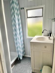 a bathroom with a sink and a window at Domek Holenderski in Mielno +8 photos