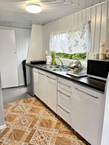 a kitchen with a sink and a counter top at Domek Holenderski in Mielno