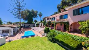 a house with a swimming pool and a yard at Cubo's Villa Las Capuchinas in Torremolinos