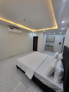 a bedroom with a large bed with white sheets and pillows at Crystal Heights in Lahore