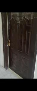a wooden door in a room with a tile floor at Crystal Heights in Lahore