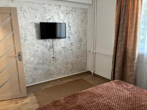 1 dormitorio con TV en la pared y cama en EMC Apartament ultracentral, en Craiova