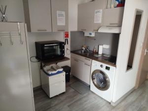 una cucina con lavatrice e microonde di Appartement vacances cap d’agde a Cap d'Agde