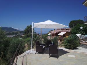 a patio with a table and an umbrella at Villa Lancellotti in Agropoli