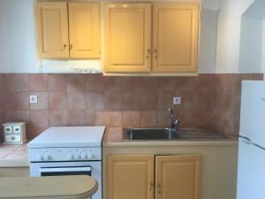 a kitchen with yellow cabinets and a sink at Cosy Studio in Lefkada town in Lefkada