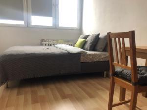 Una cama con almohadas y una silla en una habitación. en Inżynierska - Madera rooms, en Wroclaw