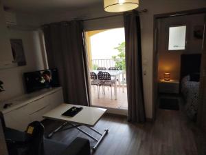un soggiorno con tavolo e vista su un patio di Appartement vacances cap d’agde a Cap d'Agde