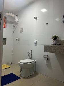 un bagno bianco con wc e doccia di SuaCasaLongeDeCasa LagoadaPrata a Lagoa da Prata