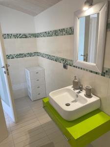a bathroom with a white sink and a mirror at Lovely Independent Villa in Plaia Grande