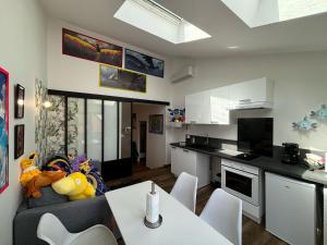 a kitchen and living room with a couch and a table at Le Poke'appart - 4pers - Confort - Rêve au Mans in Le Mans