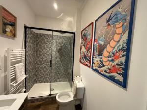 a bathroom with a toilet and a painting on the wall at Le Poke'appart - 4pers - Confort - Rêve au Mans in Le Mans