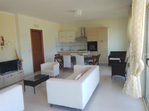 a living room with a white couch and a kitchen at Villa Lancellotti in Agropoli
