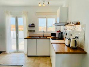 a kitchen with white cabinets and a counter top at Wayra Lodge [Kanchay] in Raposeira +39 photos