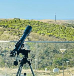 a telescope on a tripod with a hill in the background at Wayra Lodge [Kanchay] in Raposeira