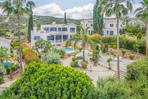 einen Luftblick auf ein großes weißes Haus mit Palmen in der Unterkunft Villa Selenia with private pool & jacuzzi in Latsi Paphos in Neo Chorio