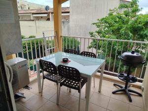 a balcony with a table and chairs and a grill at Appartement vacances cap d’agde in Cap d'Agde +14 photos