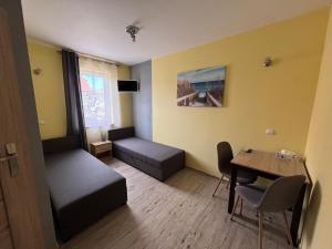mały pokój z łóżkiem i stołem w obiekcie APARTAMENT JAN-53 Krynica Morska w mieście Krynica Morska