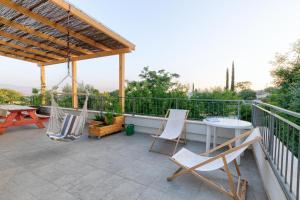 eine Terrasse mit Stühlen und einem Tisch auf einem Balkon in der Unterkunft Bednesher Vacation Apartment for Families in Ma'ale Gamla