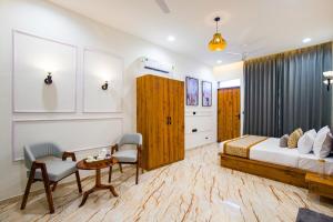 a bedroom with a bed and a table and chairs at Alaya Stays Parvam Retreat 2-BHK Villa With Private Pool, Garden, Terrace & Aravali Hill Views in Thūr +47 photos