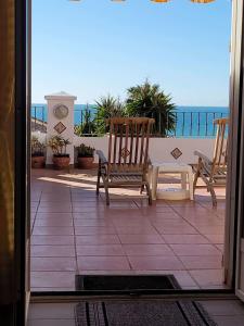 eine Terrasse mit 2 Schaukelstühlen und Meerblick in der Unterkunft Torrox Beach Club in Torrox