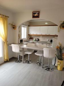 eine Küche mit einem Tisch und einigen weißen Stühlen in der Unterkunft Torrox Beach Club in Torrox