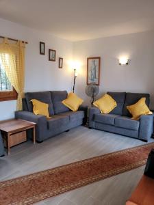 ein Wohnzimmer mit einem blauen Sofa und gelben Kissen in der Unterkunft Torrox Beach Club in Torrox + 9 Fotos