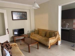 a living room with a couch and a tv at Studio in Ptolemaida in Ptolemaida