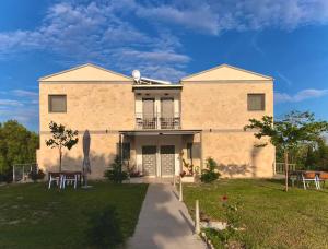 a large brick house with a yard with chairs at Delight House's in Afitos