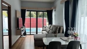 a living room with a couch and a table at Krabi Mantra Pool Villa in Ao Nang  +11 photos