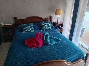 two stuffed animals sitting on a blue bed at Chambre privée in Contes