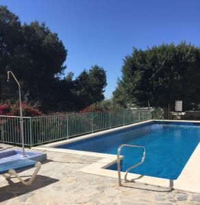 una piscina con 2 sillas junto a una valla en Las Flores de Burriana, en Nerja