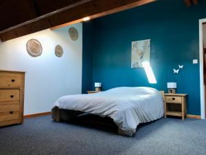 a bedroom with a blue wall with a bed and two tables at Duplex 60m2 vieux centre avec balcon in Barcelonnette