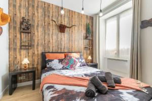 a bedroom with a bed with a wooden wall at La tanière du Cowboy in Orléans