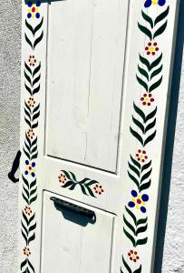 a white door with a butterfly painted on it at Cosy alpine flat with great views of Mont Blanc in Servoz +5 photos