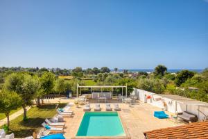 Una piscina al aire libre con tumbonas y una visera. en Villa Rilù, en Capilungo
